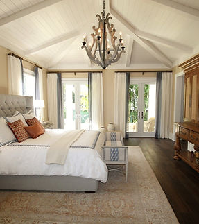 An elegant bedroom with a tufted headboard and a chandelier