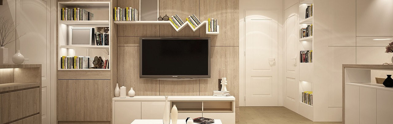 A warm, light-filled living room with bespoke shelving and natural wood furniture